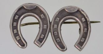 A Victorian silver double horse-shoe brooch with a loop catch, marked 