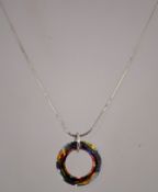 A silver chain with a crystal pendant, marked 