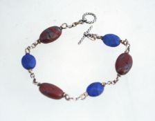 A silver, lapis lazuli and red hematite bracelet with a toggle clasp.