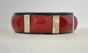 An unusual 1920s celluloid bangle, composed of pieces of printed, marbled and glittered celluloid.