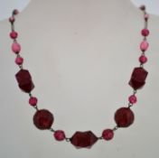 A 1930s art deco red pressed glass bead necklace, with a barrel clasp and its original stringing.