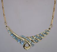A 1970s pale blue rhinestone necklace in gold tone metal with a fold over clasp,