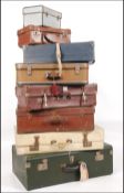 A stack of vintage suitcases from the 20th century to include leather and vinyl examples together