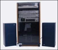 A retro silver 1980's Akai separates entertainment unit set within a teak and smoked glass cabinet