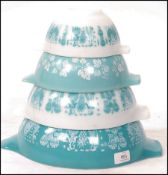 A good set of graduating original glass mid century Pyrex bowls of two tone colour with swirl