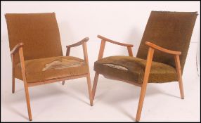 A pair of 1950's mid century Danish armchairs having angular frames with shaped elbow supports with