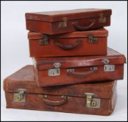 A stack of 4 vintage suitcases of leather form complete with handles and leather corners etc.