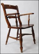 A Victorian beech and elm wood Oxford bar back armchair.