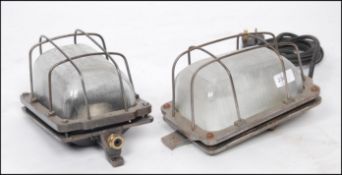 A good pair of 20th century polished and laquered steel Industrial caged bulkhead lights.