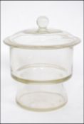 A mid century Scottish Moncrieff of Perth glass scientific laboratory jar of shaped form with lid.