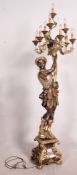 A parcel gilt and silvered floorstanding large figure of a Blackamoor holding a cornucopia shell
