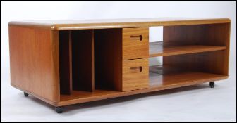 A 1970's Danish influenced teak wood Pandora's box style coffee table raised on castors having