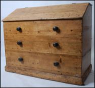 A 19th century French country pine baton bread bin being raised on square plinth with hinged top
