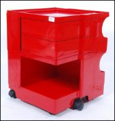 A retro 1970's Joe Columbo Boby trolley in red standing on castors and having twist out drawers,