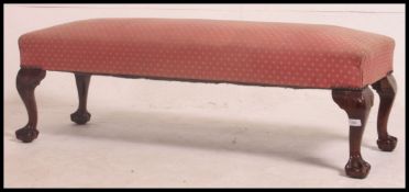 A 1930's mahogany upholstered window seat of large size with rectangular stuff over seat in rouge,