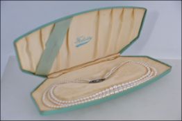 A three string faux pearl necklace by Fe