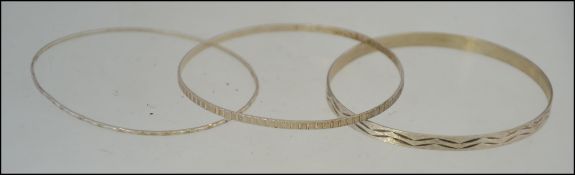 A group of three silver bangles, all thr