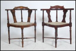 A pair of Edwardian mahogany inlaid corner chairs raised on turned legs with cross stretchers under