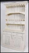 A 20th century painted pine shabby chic welsh dresser being raised on a plinth base with cupboards