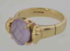 A 9ct gold hallmarked cloudy amethyst ladies dress ring having a buckle style ring.