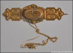 A 9ct stamped gold Victorian bar brooch having a central stone stamped to the verso 9ct.