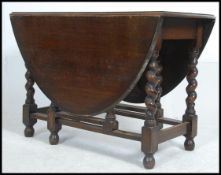 A good solid barleytwist country oak drop leaf dining table of large proportions having gate leg