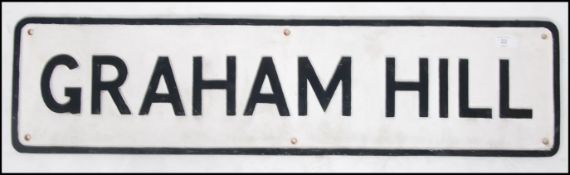 A cast iron painted road sign in the manner of Worboys for ' Graham Hill ' 92cm wide x 23cm high
