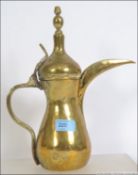 An Islamic teapot brass Dallah teapot coffee pot having tall thin spout with handle and weighted