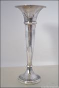A silver hallmarked trumpet solifleur vase having engine turned rim by Broadway and Co,