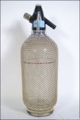 A retro mid 20th century mesh / chain mail covered glass soda syphon bottle. Measures 37cm high.