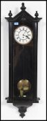 An early 20th century large ebonised mahogany vienna regulator wall clock having enamel dial with
