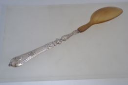 A silver and horn large table serving spoon. The rococo handle in silver with horn bowl. unmarked.