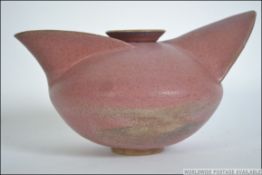 A stylised studio pottery dark pink earthenware teapot of unusual form from Devon having impressed