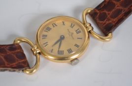 A ladies 18ct gold Baume & Mercier wristwatch - dress watch having roman numeral ring with faceted