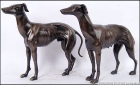 A pair of vintage style Greyhound figures of a bitch and a dog. Both in alert stances. 29cm long.