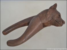 An early 20th century black forest wooden nut cracker in the form of a bear. Measures 17cm long.