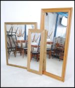 A large gilt framed 20th century antique style wall mirror together with a pine tall mirror and a