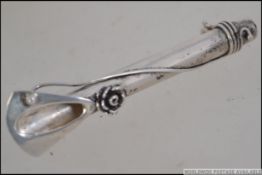 A silver ladies 20th century bar brooch of cylindrical form adorned with poseys. Pin to verso.