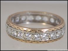 A 9ct gold eternity band ring adorned with clear stones to the centre. Size Q.5 / Weight 3.