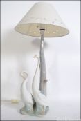A good Nao Spanish ceramic table lamp having base of goose being raised on naturalistic plinth.