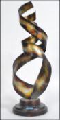 A large multi-coloured entwined spiral metal sculpture on a metal plinth base. Measures 63cm high.