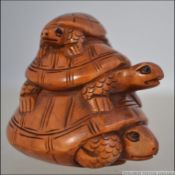 A carved Japanese wooden netsuke of three tortoises ( see illustrations )