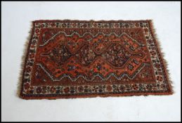 An early 20th century Persian handwoven rug having 3 central joined medallions raised on ochre