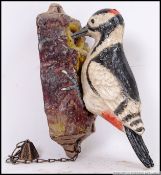 A cast iron Woodpecker door knocker. When knocked the Woodpecker pecks a tree. 13cm long.