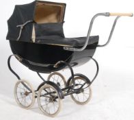 A vintage mid century black metal and canvas covered childs dolls pram by Swan.