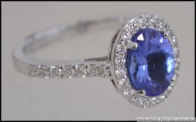 An 18ct white gold, tanzanite and diamond cluster ring of approx 2.5cts of diamonds. Total weight 4.