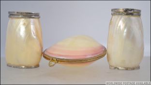 A pair of silver collared mother of pearl salt and pepper pot condiments,