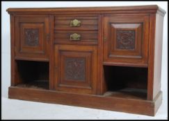 An Edwardian mahogany Art Nouveau dresser base raised on plinth with carved cupboards and drawers