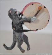 An unusual cold painted bronze miniature pug dog playing a large drum being handpainted.