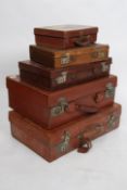 A stack of 5 vintage suitcases to include leather and canvas examples all of graduating sizes.